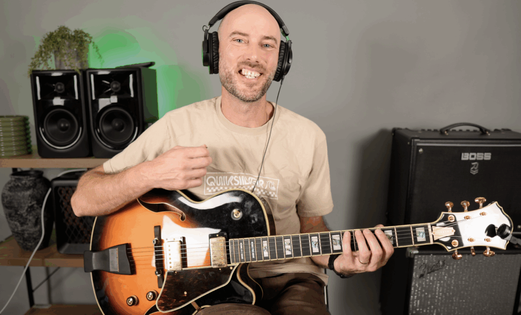 Glen Hitchon playing a jazz guitar, smiling during a YouTube video recording session